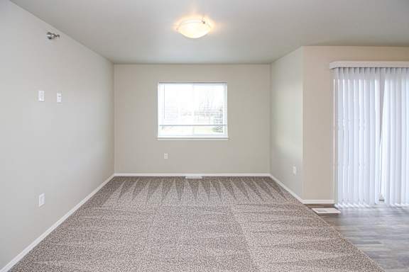 A room with a carpeted floor and a window.