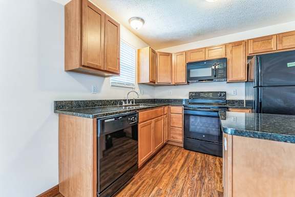 a kitchen with black appliances and wooden cabinets