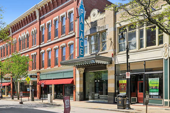 A street view of a building with a blue sign that says "The Palace".
