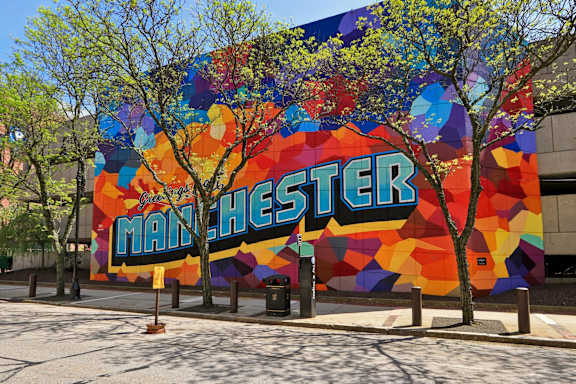 A large mural on a building with the word "MANCHESTER" written on it.