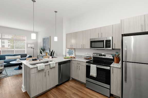 A modern kitchen with stainless steel appliances and wooden cabinets.