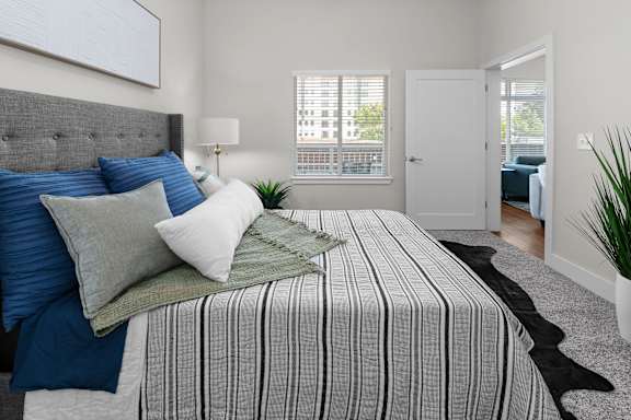 A bedroom with a large bed and a grey headboard.