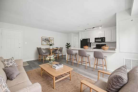 A living room with a couch, chairs, and a coffee table.
