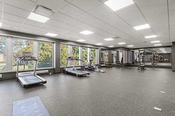 A spacious gym with treadmills, exercise bikes, and other equipment.