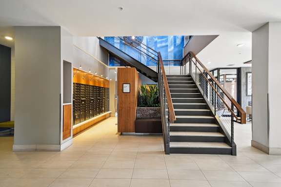A staircase with a wooden handrail and a glass window above it.