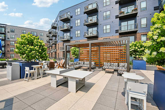A patio with a table and chairs is surrounded by apartment buildings.