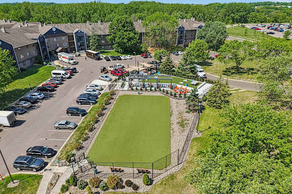 A park with a green lawn and a soccer goal.