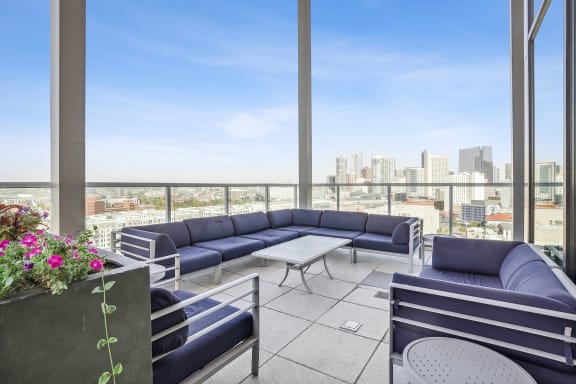 a patio with blue couches and a view of the city