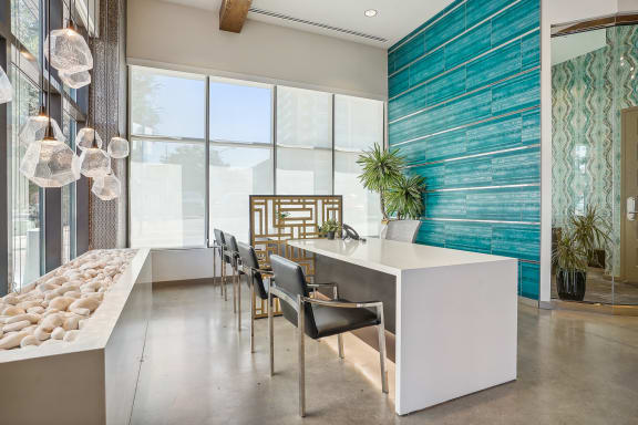a dining room with a long table and chairs in front of a wall of windows