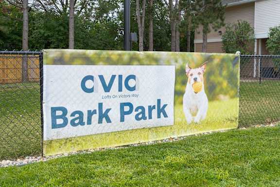 A sign for Cvic Bark Park with a dog on it. at AVIA Lofts on Victors Way, Ann Arbor, MI