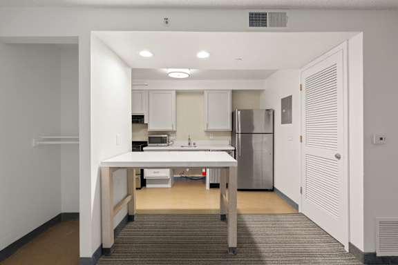 A kitchen area with a table and chairs in the middle of the room. at AVIA Lofts on Parkway, Vancouver, 98662