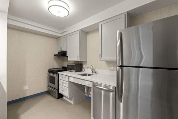A kitchen with a stainless steel refrigerator, microwave, oven, and sink. at AVIA Lofts on Parkway, Washington , 98662