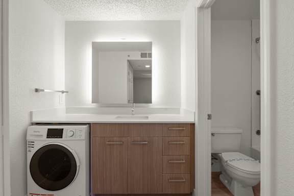 A small bathroom with a washing machine and a toilet. at AVIA Lofts on Parkway, Washington