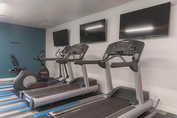 A gym with treadmills at AVIA Lofts on Victors Way, Michigan