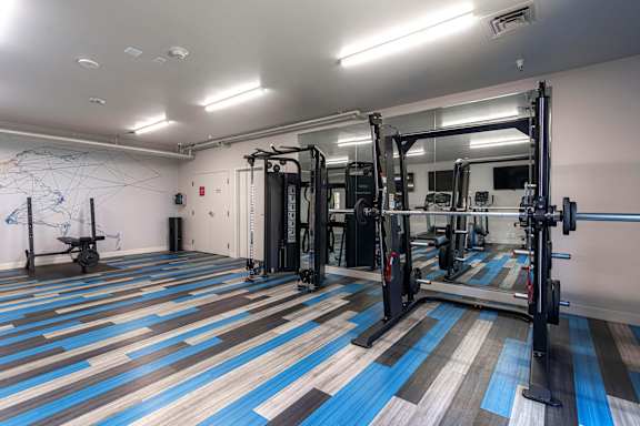 A gym with a blue and brown floor at AVIA Lofts on Victors Way, Ann Arbor Michigan