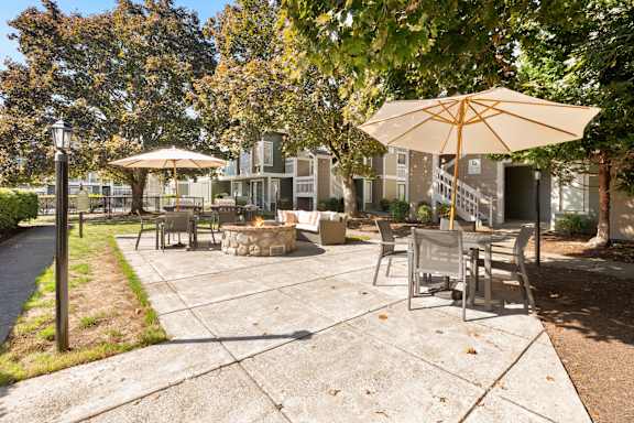 a patio with tables and umbrellas in front of a house at AVIA Lofts on Parkway, Vancouver