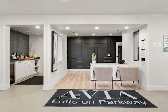 A black and white foyer with a rug that says "Lofts on Parkway".