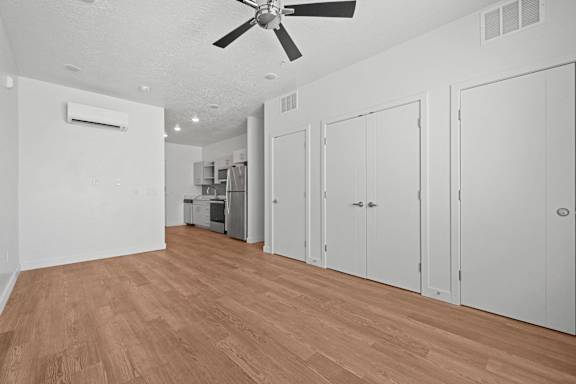 A room with a ceiling fan and wooden flooring.
