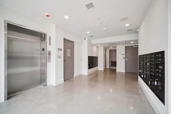 A long hallway with a wall of lockers on the right.