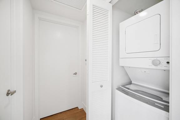 A white washing machine is in a small laundry room.
