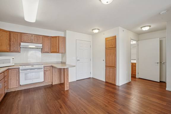 A kitchen with wooden cabinets and a white oven.