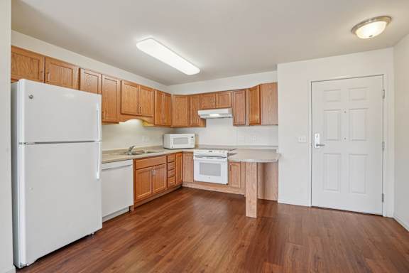A kitchen with wooden cabinets and a white refrigerator.
