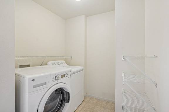 A white washing machine in a small, empty room.