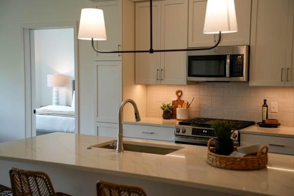 A kitchen with a white counter top and a sink.