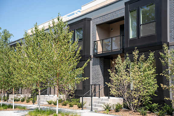 A modern building with a black facade and large windows.