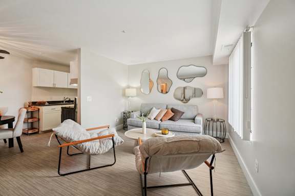 A modern living room with a white couch, a chair, and a table.