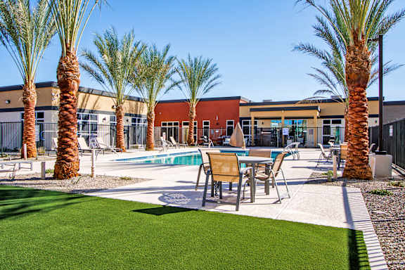 our apartments have a pool and a patio with chairs and tables