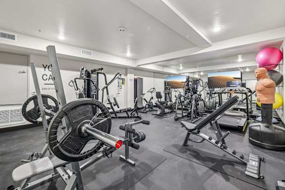 a gym with exercise equipment and windows in a building