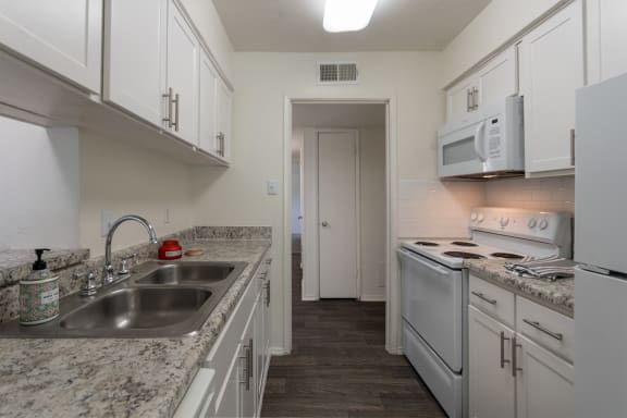 This is a photo of the kitchen of a 1245 square foot 2 bedroom apartment at Cambridge Court Apartments in Dallas, TX.