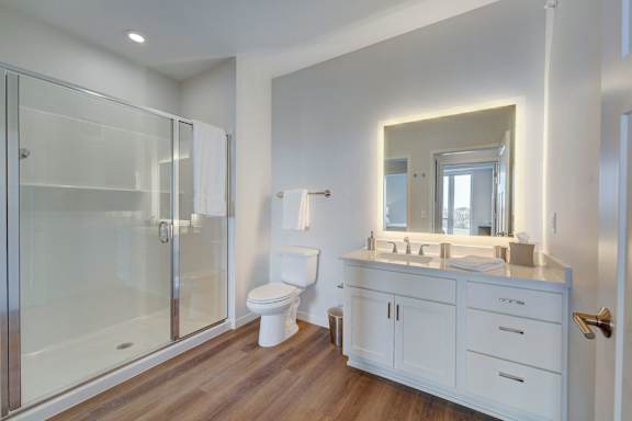 a white bathroom with a shower toilet and sink