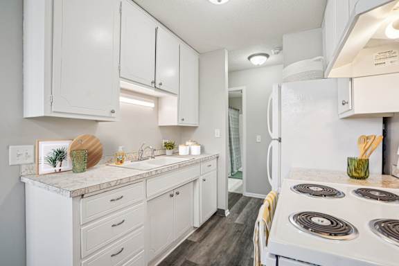 A white kitchen with a stove top oven.
