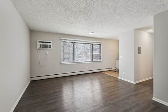 A room with a window and a wall-mounted air conditioner unit.