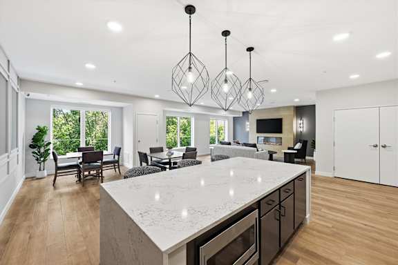 A modern kitchen with a large island and pendant lights.