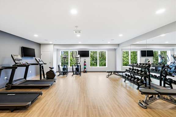 A spacious gym with treadmills, elliptical machines, and other exercise equipment.