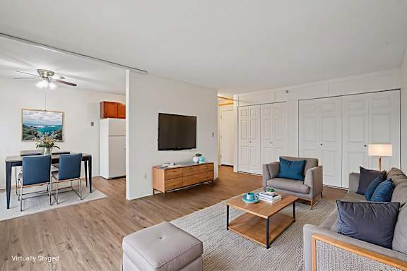 A living room with a grey couch, a wooden coffee table, and a painting on the wall.