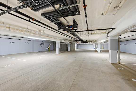 A large, empty warehouse with a concrete floor and white walls.