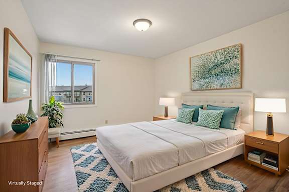 A bedroom with a large bed, a nightstand, and a painting on the wall.