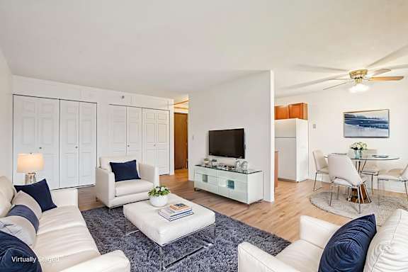 A living room with white furniture and a flat screen TV.