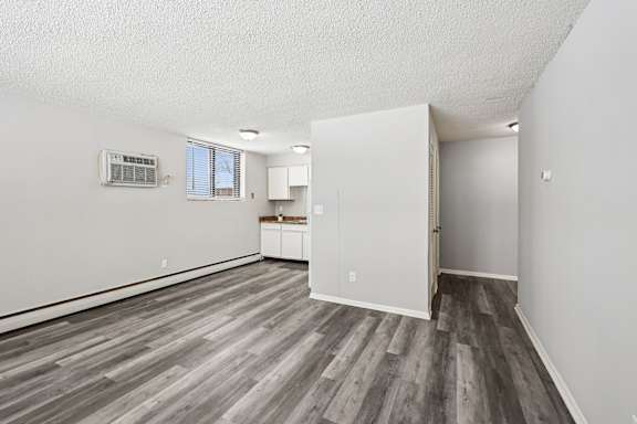 A room with a wood floor and white walls.