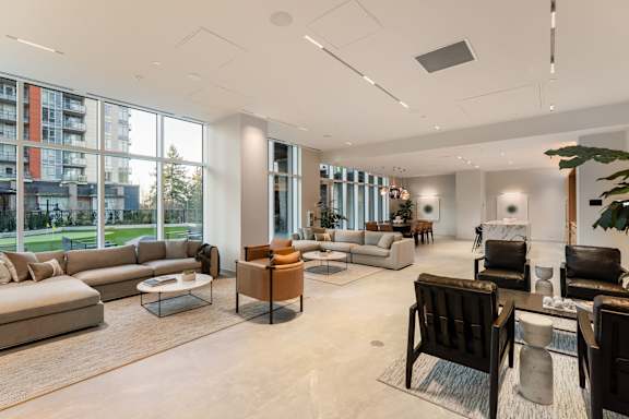 A spacious living room with a large window overlooking a green area.