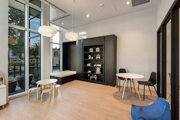 A modern room with a table, chairs, and a cabinet with glass doors.
