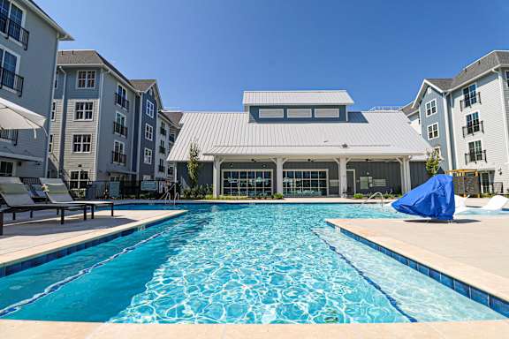 a swimming pool with an apartment building in the background  at Oak Grove at Blake Farm, Wilmington, North Carolina