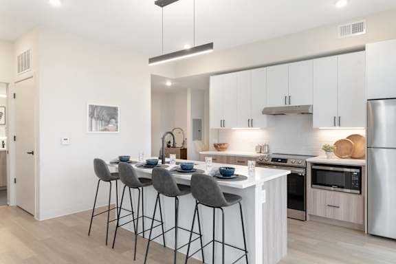 A modern kitchen with a dining table and chairs.