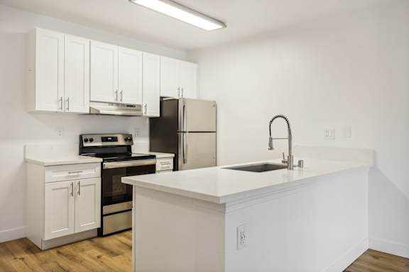 A kitchen with white cabinets and appliances.