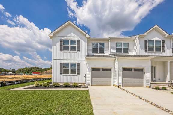 A white two-story house with a garage.
