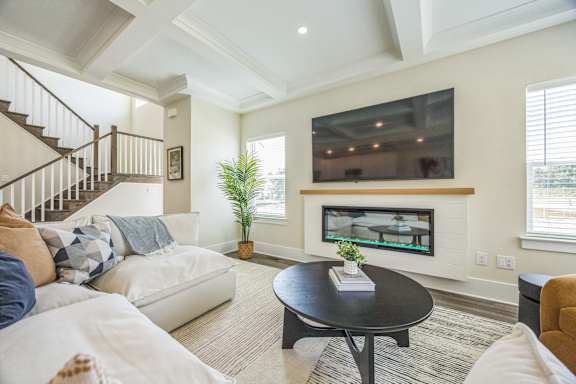 A living room with a white couch and a black coffee table.